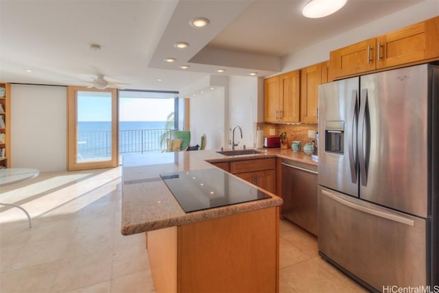 kitchen featuring expansive windows, a water view, sink, appliances with stainless steel finishes, and kitchen peninsula