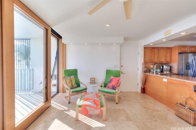 sitting room featuring ceiling fan, sink, and light tile patterned floors