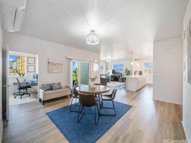 dining area with light hardwood / wood-style floors and a notable chandelier