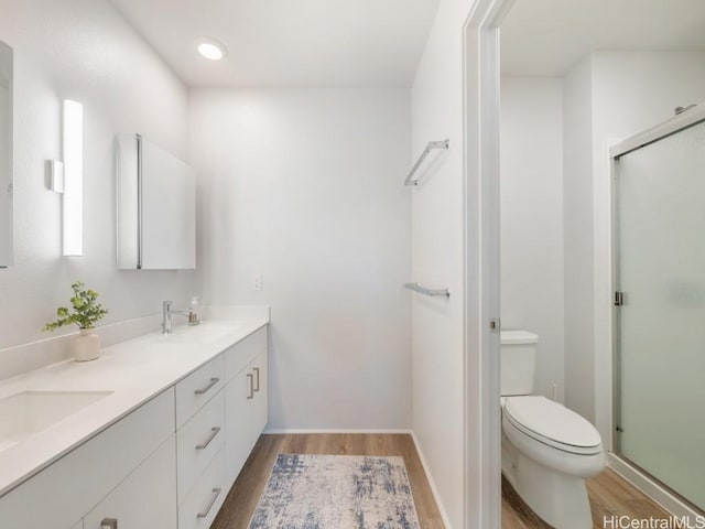 bathroom featuring hardwood / wood-style floors, vanity, toilet, and walk in shower