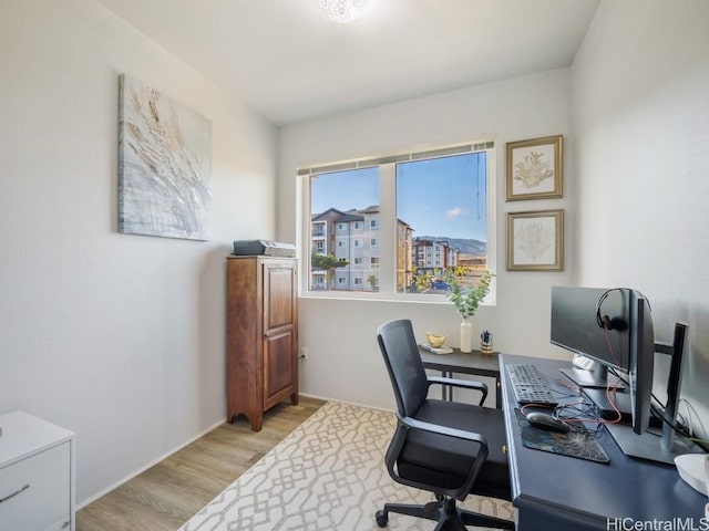 home office with light hardwood / wood-style floors