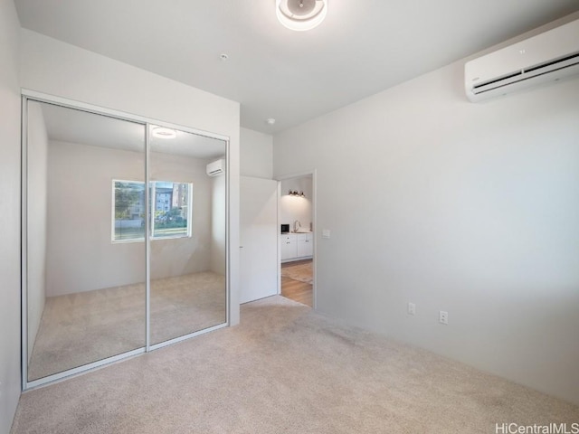 unfurnished bedroom with a wall unit AC, light carpet, and a closet