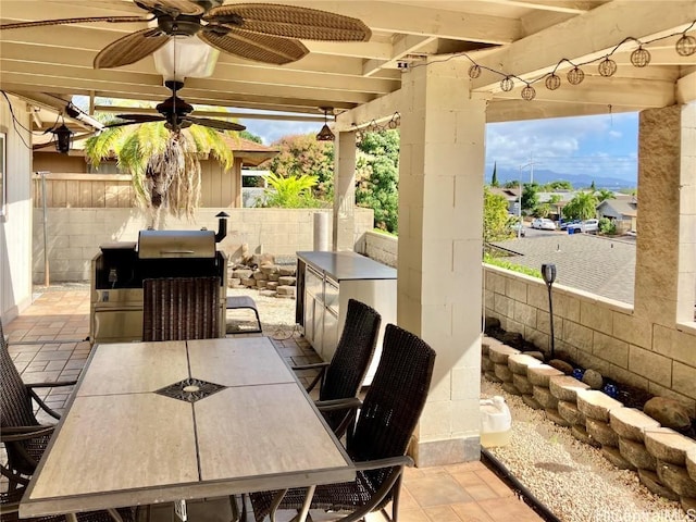 view of patio with ceiling fan, area for grilling, and grilling area