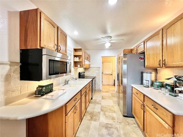 kitchen featuring decorative backsplash, kitchen peninsula, stainless steel appliances, ceiling fan, and sink