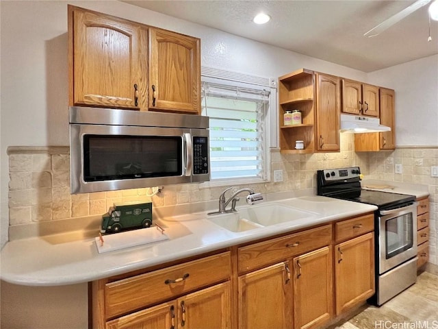 kitchen with backsplash, ceiling fan, sink, and appliances with stainless steel finishes