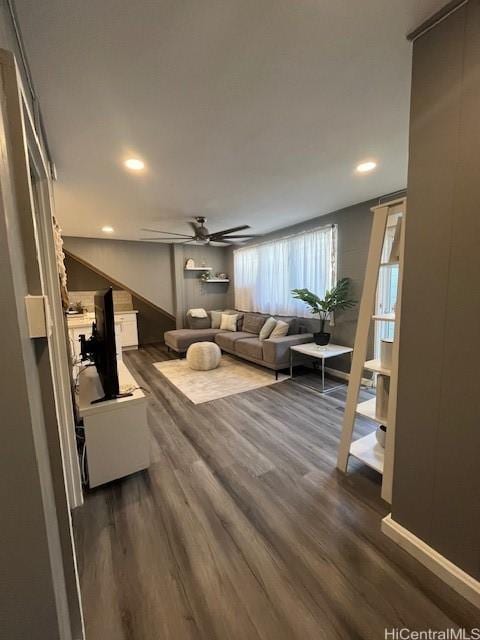 living room featuring ceiling fan and dark hardwood / wood-style floors