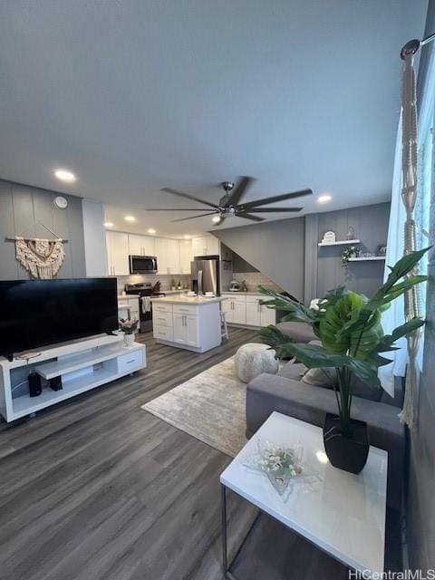 living room with ceiling fan and dark wood-type flooring