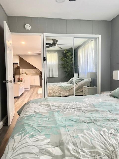 bedroom with a closet, light hardwood / wood-style floors, and ceiling fan