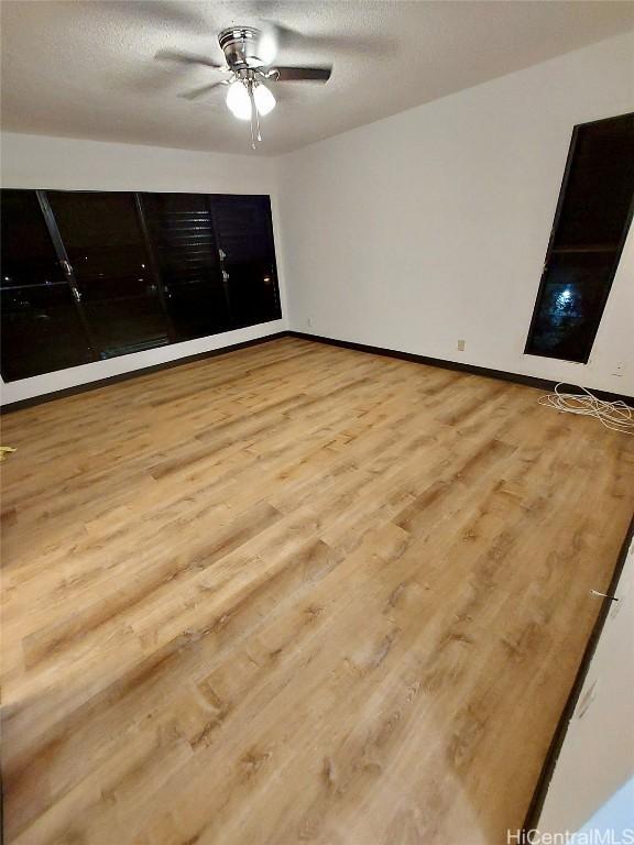 unfurnished bedroom featuring a textured ceiling, light hardwood / wood-style flooring, and ceiling fan