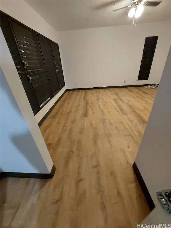 spare room featuring light wood-type flooring and a textured ceiling