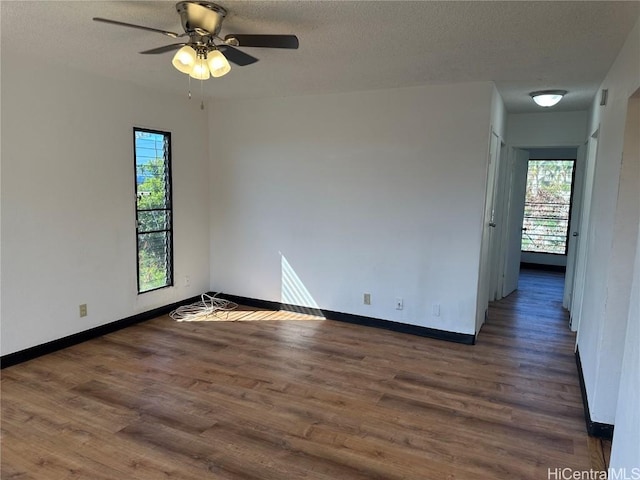 unfurnished room with dark hardwood / wood-style floors, ceiling fan, and a textured ceiling