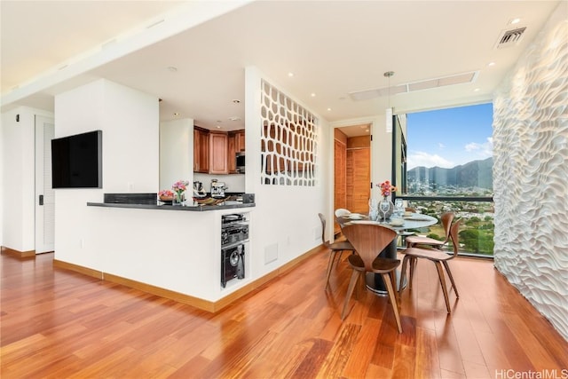 dining room with light hardwood / wood-style floors and expansive windows