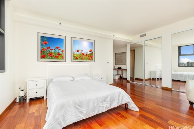 bedroom featuring hardwood / wood-style floors and two closets