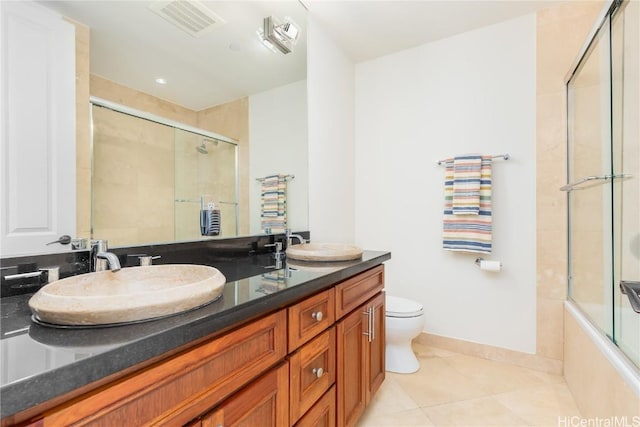 full bathroom with tile patterned floors, combined bath / shower with glass door, toilet, and vanity