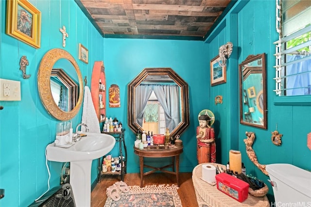 bathroom featuring wood-type flooring, wooden walls, toilet, and wooden ceiling