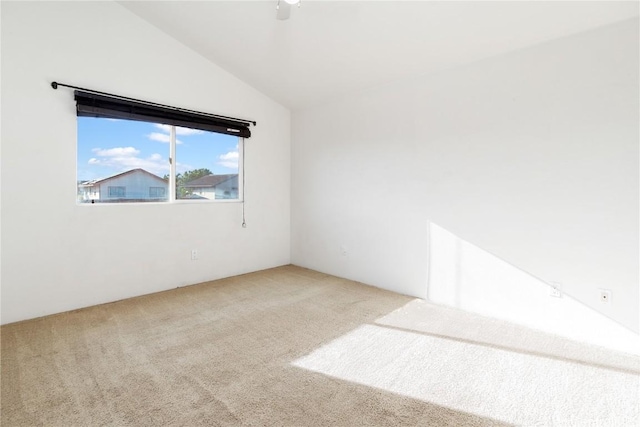 empty room with lofted ceiling and carpet flooring