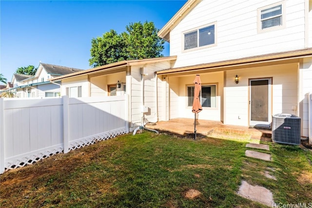 back of property with a yard, central AC unit, a patio area, and fence