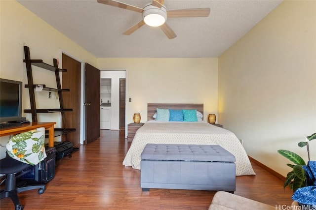 bedroom featuring ceiling fan, washer / clothes dryer, dark hardwood / wood-style flooring, and a textured ceiling