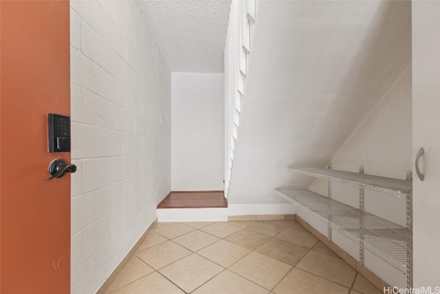 bathroom with a textured ceiling and tile patterned floors