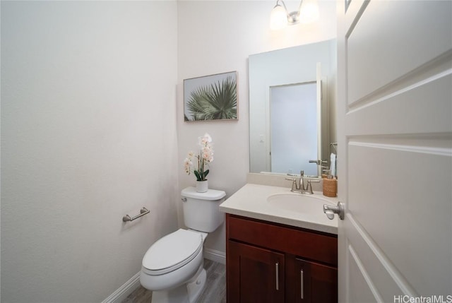 bathroom featuring wood-type flooring, vanity, and toilet