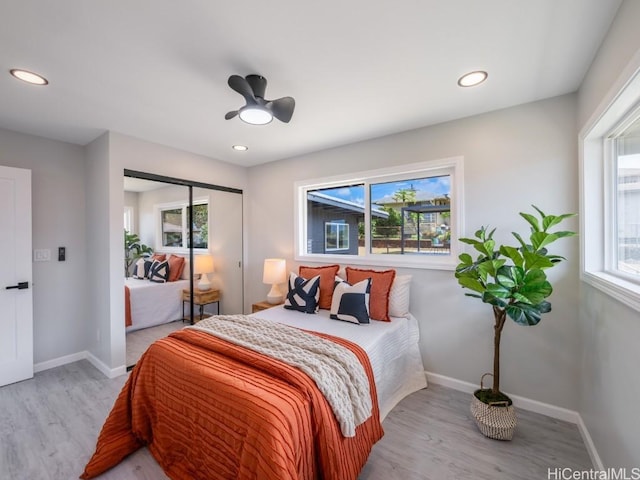 bedroom featuring ceiling fan, a closet, and light wood-type flooring