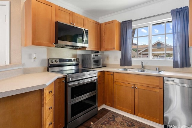 kitchen with dark wood-type flooring, crown molding, sink, and stainless steel appliances