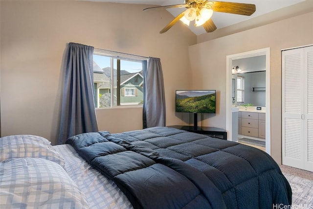 bedroom featuring light carpet, ensuite bathroom, vaulted ceiling, ceiling fan, and a closet