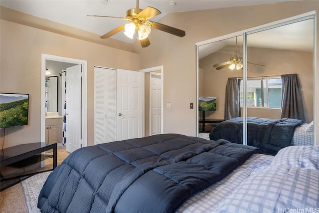 bedroom with ensuite bath, ceiling fan, carpet, and lofted ceiling