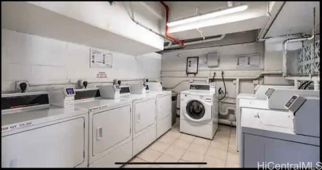 washroom featuring washing machine and dryer and light tile patterned floors