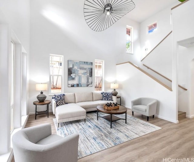 living room with light hardwood / wood-style flooring and a towering ceiling