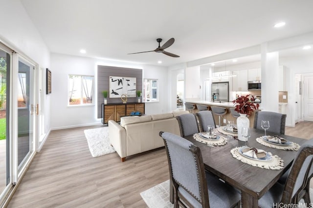 dining area with ceiling fan and light hardwood / wood-style flooring