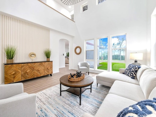 living room with hardwood / wood-style floors and a towering ceiling