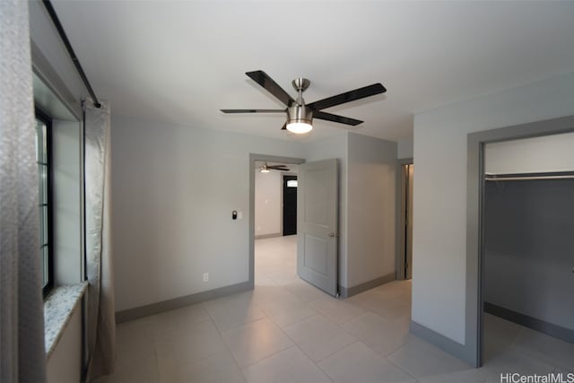 unfurnished bedroom with ceiling fan and a closet