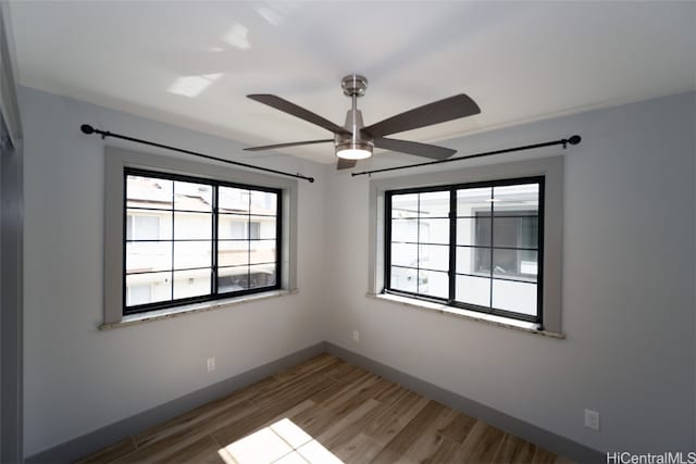 unfurnished room with hardwood / wood-style floors, plenty of natural light, and ceiling fan