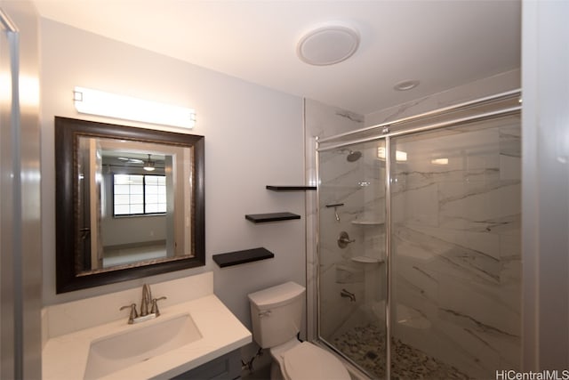 bathroom featuring vanity, toilet, and a shower with door