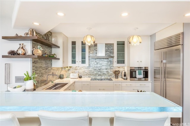 kitchen featuring sink, wall chimney exhaust hood, white cabinets, decorative backsplash, and stainless steel appliances