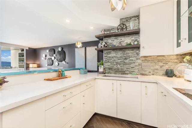 kitchen with backsplash, white cabinetry, and black electric stovetop