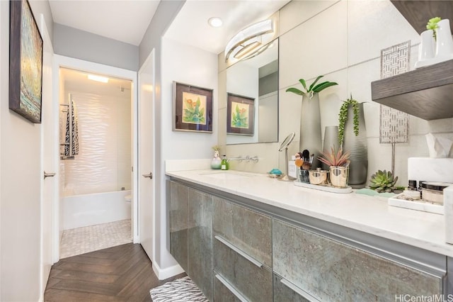 bathroom with toilet, vanity, and parquet flooring