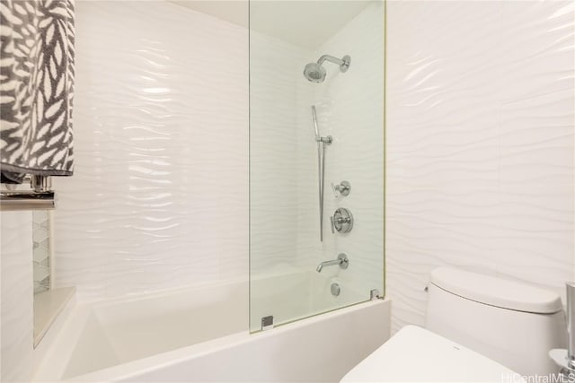 bathroom featuring tiled shower / bath combo and toilet