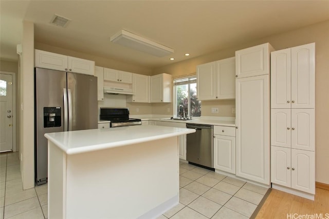 kitchen with appliances with stainless steel finishes, custom exhaust hood, a kitchen island, sink, and white cabinetry