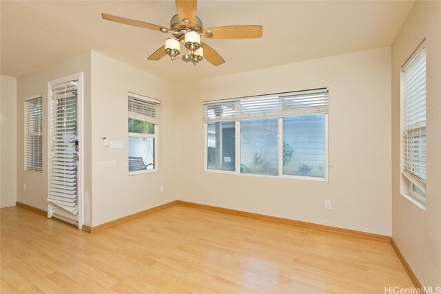 empty room with plenty of natural light, ceiling fan, and light hardwood / wood-style flooring