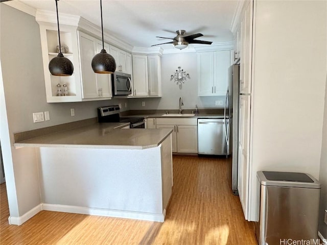 kitchen with sink, stainless steel appliances, light hardwood / wood-style floors, decorative light fixtures, and white cabinets