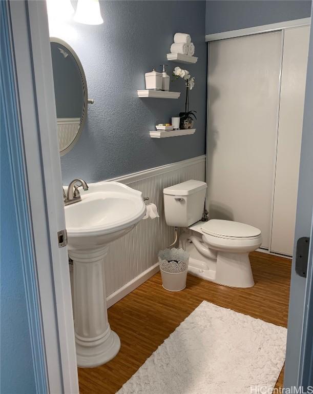 bathroom with hardwood / wood-style floors, toilet, and sink