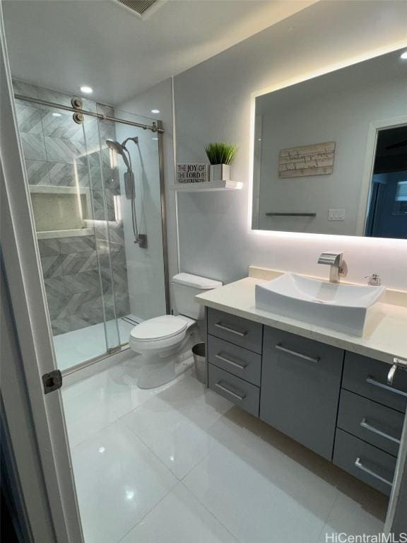 bathroom featuring tile patterned flooring, vanity, toilet, and an enclosed shower