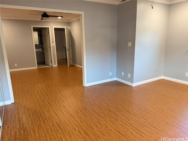 empty room featuring ceiling fan, wood-type flooring, and ornamental molding