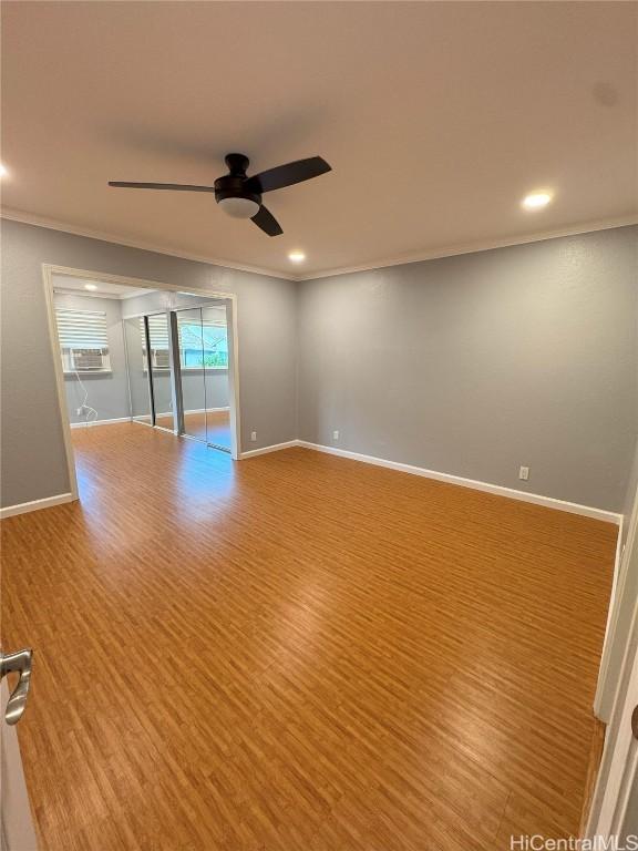 empty room with ceiling fan, crown molding, and light hardwood / wood-style floors