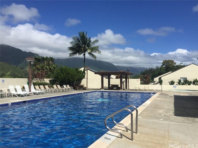 view of swimming pool with a pergola, a mountain view, and a patio