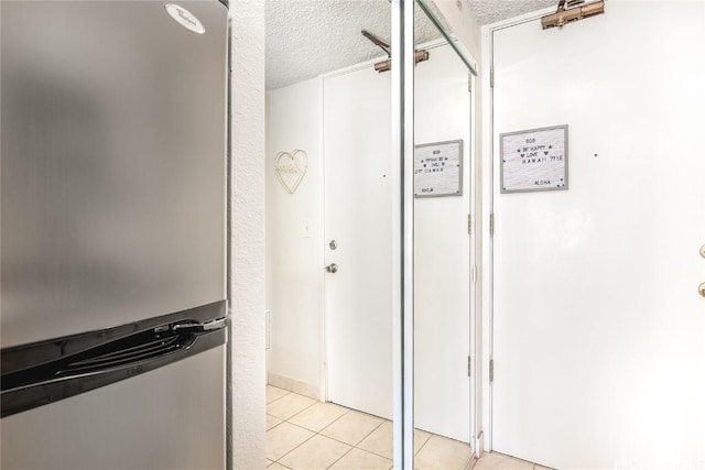 interior space with light tile patterned floors and a textured ceiling