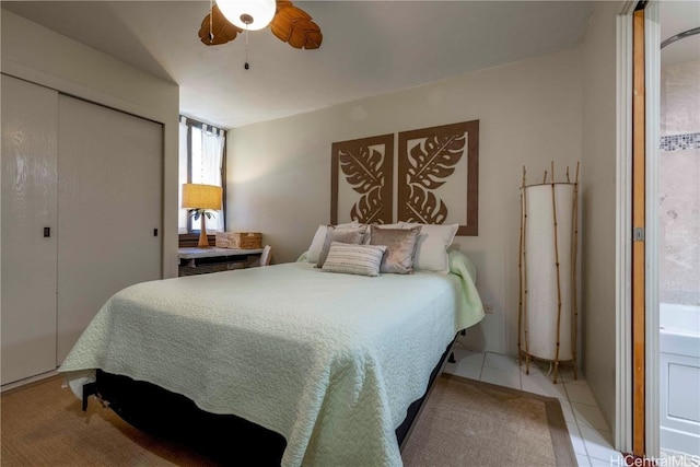 tiled bedroom featuring ceiling fan and a closet