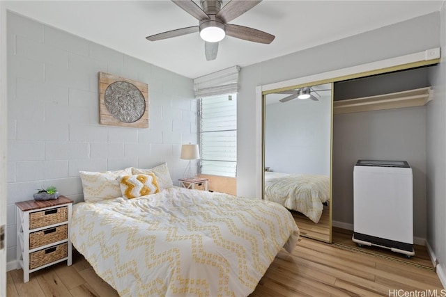 bedroom with ceiling fan, a closet, and light hardwood / wood-style floors